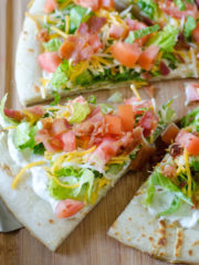 slice of cold pizza with lettuce, bacon and tomatoes as toppings