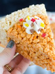 holding rice krispies treats shaped as pumpkin pie slice